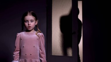 Karanlıkta yalnız korkmuş kız, arkasında sürünen korkunç adam, çocukluk korkusu