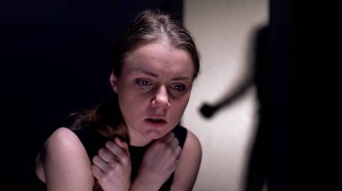 Korkmuş kadın kurban ağlıyor, seri siluet odaya giriyor, korku