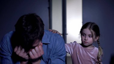 Umutsuzluk içinde ağlayan kederli adam, babayı teselli eden küçük kız, aile desteği