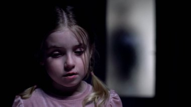 Küçük kız ağlıyor, cam kapının arkasında suçlu silueti, kurban kaçırma