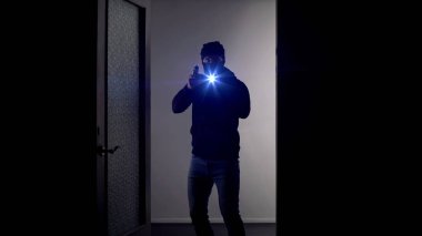 Kapıda silahlı ve el feneri olan maskeli adam, polis teşkilatı, olay yeri