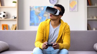 Vr kulaklık, gelecekte video oyunu oynarken joystick ile Afrikalı-Amerikalı genç çocuk