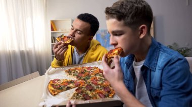 Afrikalı-Amerikalı ve beyaz genç arkadaşlar pizza, sağlıksız gıda zevk
