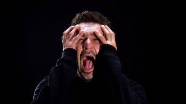Korkmuş erkek siyah arka plan, endişeli psikopat, kabuslar üzerinde bağırıyor