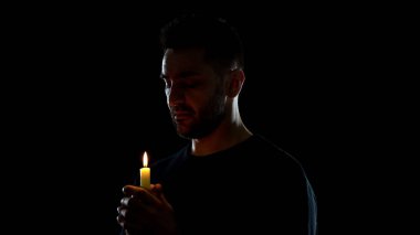 Yanan mum ellerine bakan dua eden erkek, manevi destek, anma ritüeli