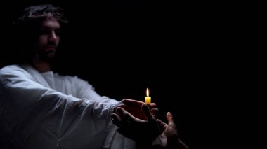 Yanan ışık tutan İsa ellerini kaplayan erkek, dini umut, inanç sembolü