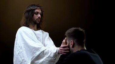 Tanrı'nın Oğlu karanlık arka plan, manevi yardım ağlayan umutsuz adam destekleyen