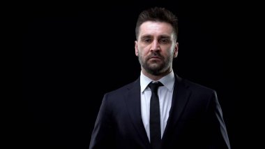 Resmi takım elbise içinde kendine güvenen şirket patronu kameraya bakıyor, başarılı politikacı