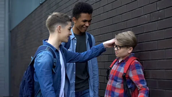 残忍的十几岁的男孩嘲笑年轻学生的眼镜 学校欺凌 — 图库照片
