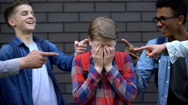 Kötü niyetli gençler çocuk ağlama, zorbalık depresif kurbanı parmaklar işaret