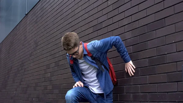 Duvara yakın yatan, kendini kötü hisseden, ani acı çeken, sağlık sorunu olan bir öğrenci.