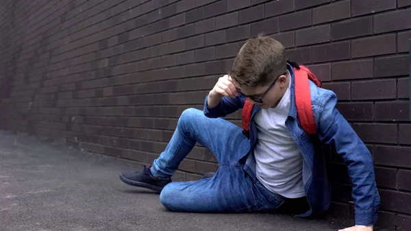 Yumruklu okul çocuğu arka bahçede acı hissederek yatarken, zorbalık kurbanı sindirdi