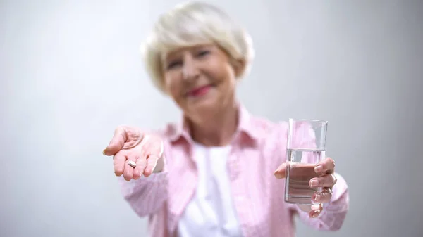 Mujer Anciana Sonriente Proponiendo Píldoras Agua Tratamiento Enfermedades Vejez —  Fotos de Stock