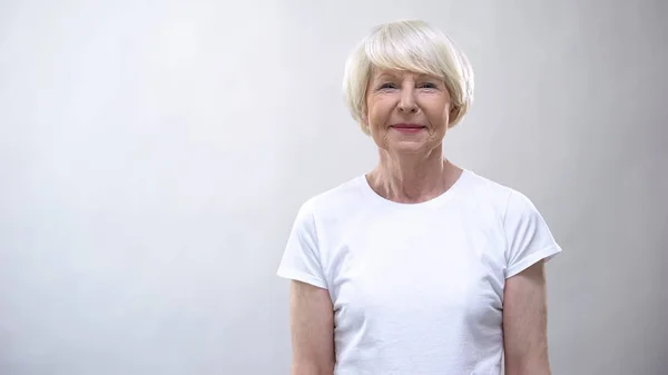 Glad Senior Lady Tittar Kamera Mot Grå Bakgrund Social Trygghet — Stockfoto
