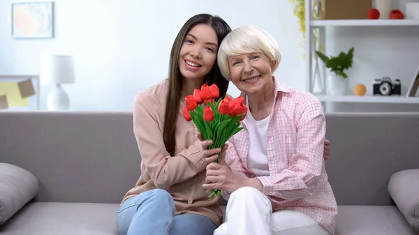 Old Woman Granddaughter Holding Bunch Tulips Looking Camera — Stock Photo, Image