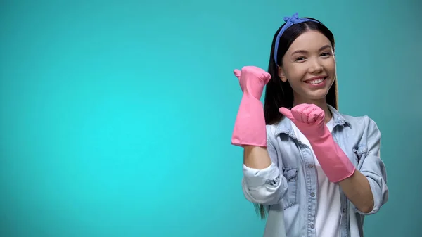 Lächelnde Junge Hausfrau Handschuhen Die Finger Den Hintergrund Zeigend Empfiehlt — Stockfoto