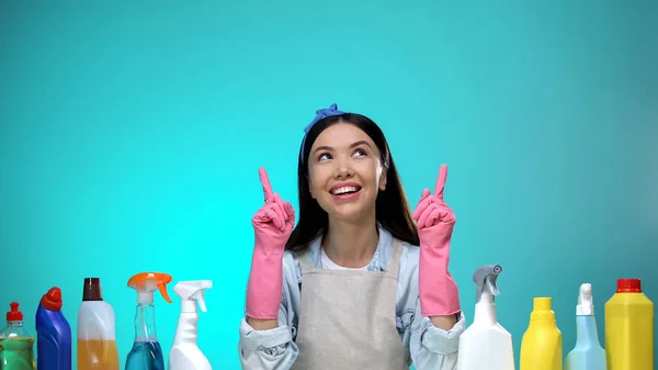 Vrolijke Huisvrouw Wijzende Vingers Omhoog Detergenten Tafel Housekeeping Concept — Stockfoto