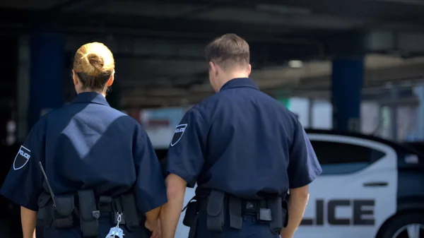 Zwei Polizisten Fuß Zum Auto Patrouillieren Bezirk Zusammen Rückansicht — Stockfoto