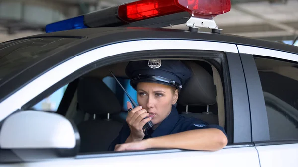 ポータブルラジオを取って車の中で警察の女性は 地域のパトロール中に通知 — ストック写真