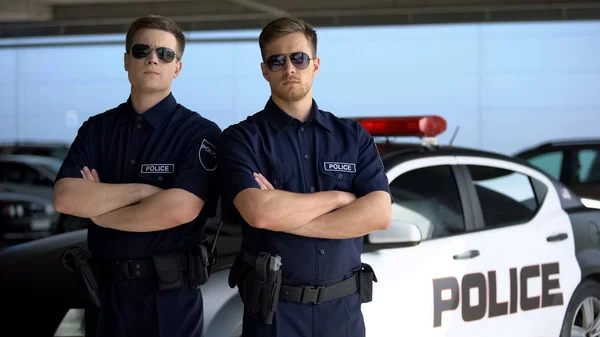 Självsäkra Manliga Officerare Solglasögon Stående Mot Polisbil Bakgrund — Stockfoto