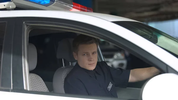 Selbstbewusster Männlicher Polizeibeamter Der Aus Dem Streifenwagen Die Kamera Blickt — Stockfoto
