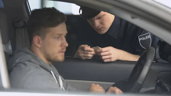 Strenger Polizist Kontrolliert Männlichen Führerschein Nach Geschwindigkeitsüberschreitung — Stockfoto