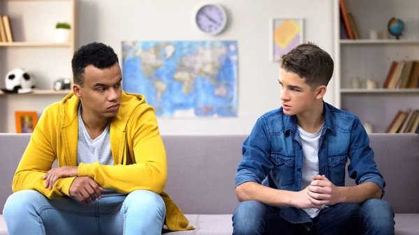 Çok ırklı genç çocuklar kanepede ayrı oturan, birbirlerine kızgın, kavga