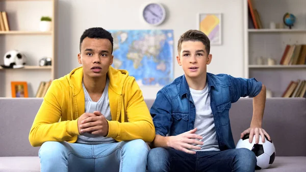 Heyecanlı multiracial genç taraftarlar evde futbol maçı izlerken, boş zaman aktivitesi