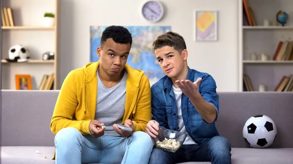 Çok ırklı erkek genç arkadaşlar futbol tartışırken yeme patlamış mısır, boş zaman maç