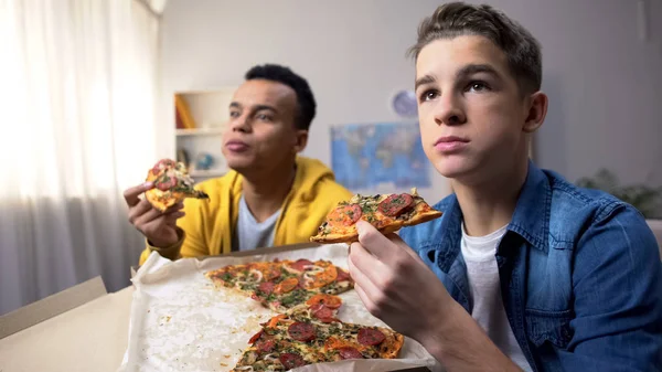 Zwei Multiethnische Männliche Teenager Die Pizza Essen Und Fernsehen Schauen — Stockfoto