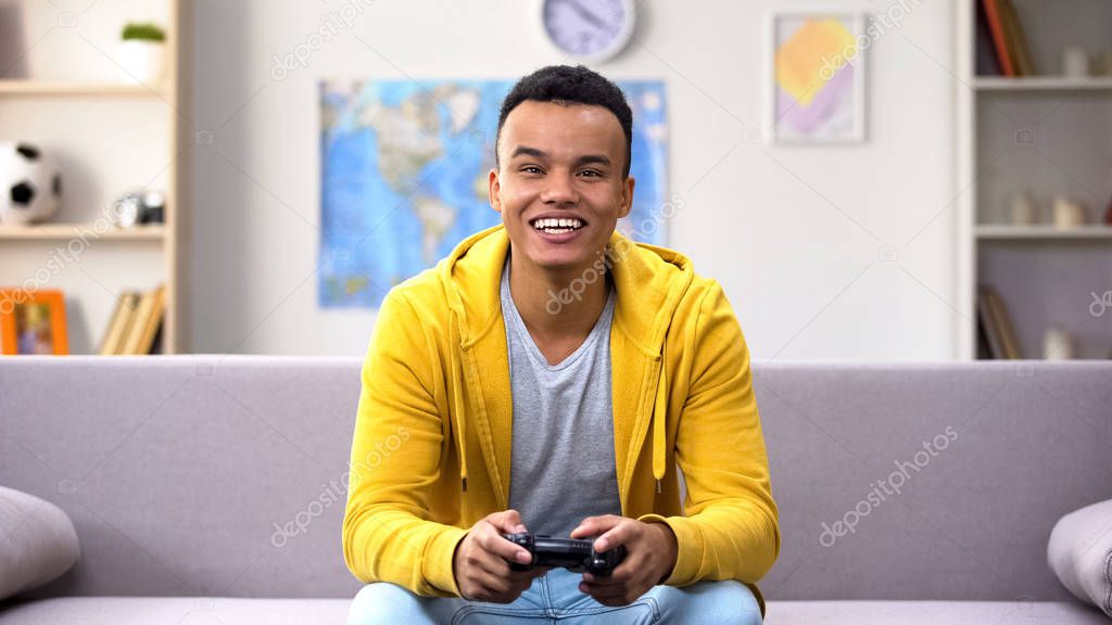 Game addicted Afro-American teenage boy winning computer game, procrastination