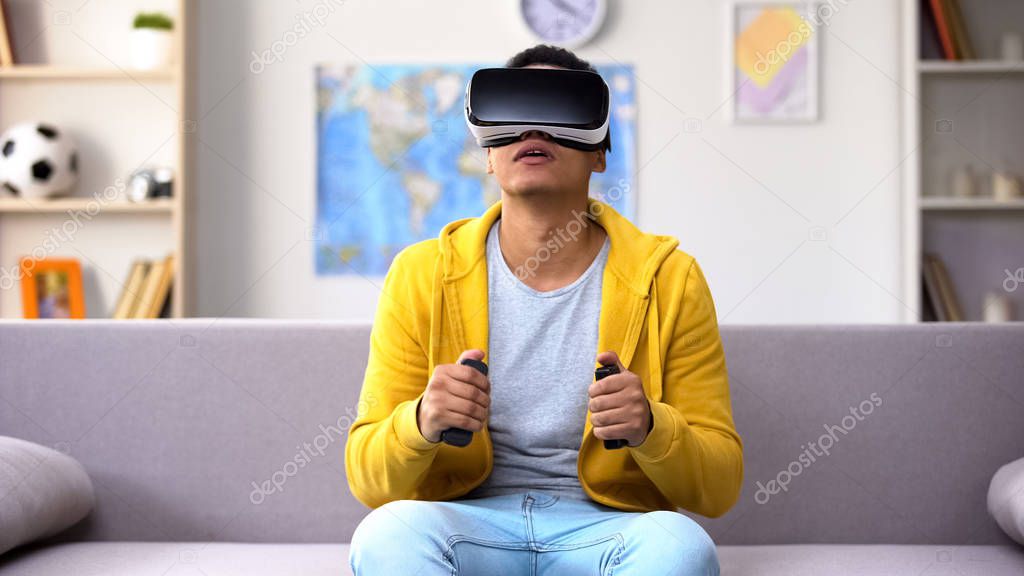 African-American male teenager playing video game in VR headset, imagination