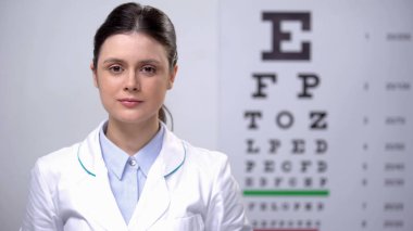Göz grafiğine karşı duran neşeli kadın oculist, görme check-up, sağlık