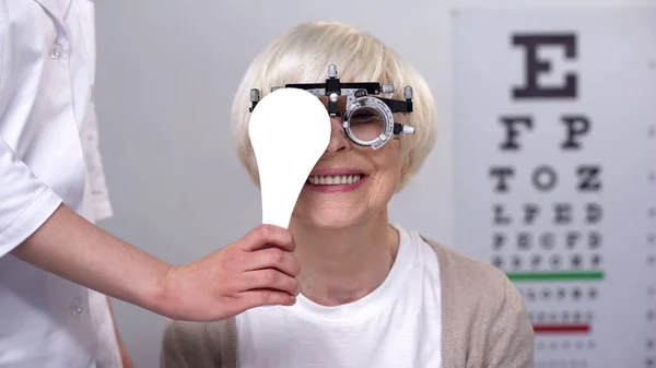 Optiker Stänga Ena Ögat Till Leende Äldre Kvinna Phoropter Perfekt — Stockfoto