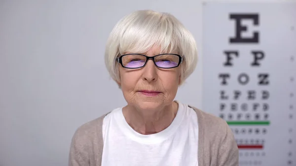 老年妇女挤压眼睛通过眼镜 不适当的镜头 医疗保健 — 图库照片