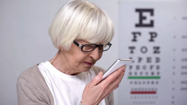 老年女性试图阅读智能手机 字体小 视力不佳问题 — 图库照片