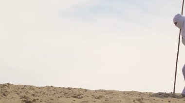 Kuma düşen Müslüman kıyafetleri içinde yorgun gezgin, yaşam zorlukları, zor yol