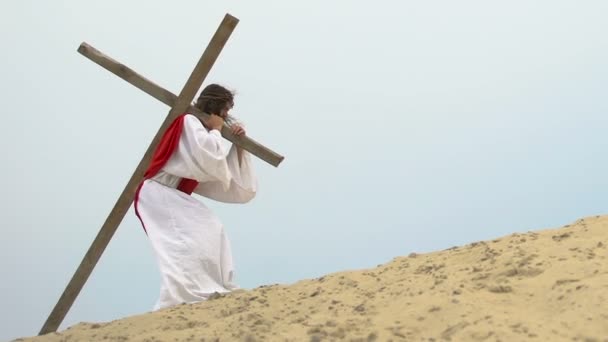 Jesús agotado llevando pesada cruz de madera caminando hacia la colina del Calvario, crucifixión — Vídeos de Stock