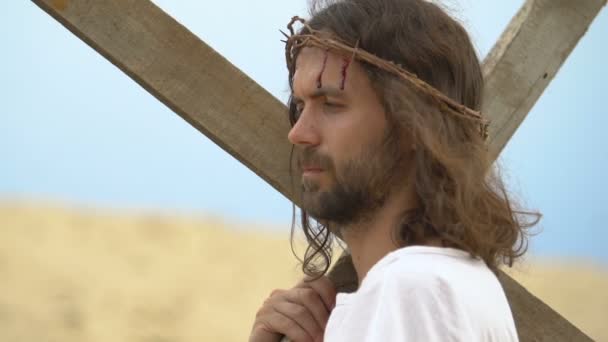 Jesús sosteniendo pesada cruz, volteando sangriento rostro al cielo, orando padre por la gente — Vídeo de stock