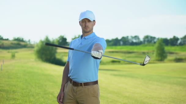 Guapo jugador masculino con club calentando mejillones de mano antes del juego de golf, deporte — Vídeos de Stock