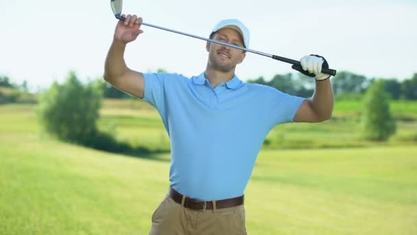 Trygg golfspelare med klubb bakom ryggen leende på kameran på kurs, idrott — Stockvideo