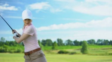 Deneyimsiz kadın golf oynarken, başarısız girişimi topa vurmak için, kaybeden