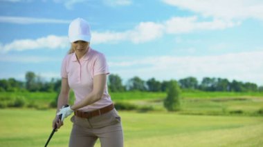 Genç kadın golfçü topa vurmak, başarılı atış seviniyor, evet işareti gesturing