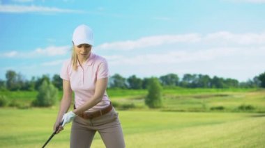 Golf kulübü topa vuran genç kadın, başarısız şut, talihsizlik ile şok