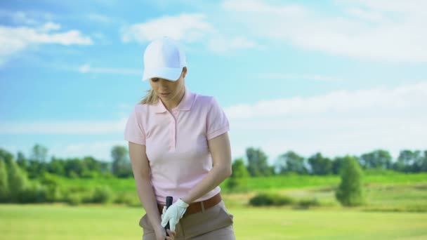 Female golf player hitting ball with club at course, training and sport, hobby — Stock Video