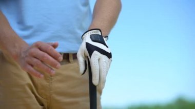 Tecrübeli adam golf oyuncusu beyaz eldiven tutarak demir kulüp spor oyunu hazır