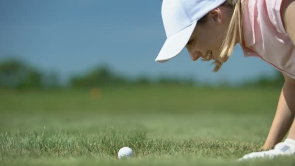 Πανούργα γυναίκα χτύπημα μπάλα του γκολφ στην τρύπα με το δάχτυλο, έχοντας τη διασκέδαση κατά τη διάρκεια του παιχνιδιού — Αρχείο Βίντεο