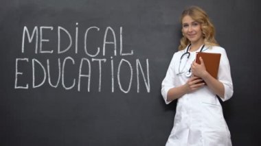 Tıp eğitimi kitabesi yanında duran öğrenci, geleceğin profesyonel doktoru