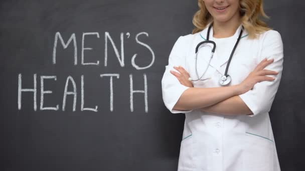 Уролог, стоящий рядом со словами мужского здоровья, медицинский осмотр для предотвращения простатита — стоковое видео