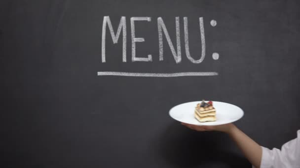 Plato de mano con pastel en el fondo del menú, deliciosos postres en el restaurante — Vídeo de stock